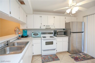 Kitchen with sink, white cabinetry, light tile pat