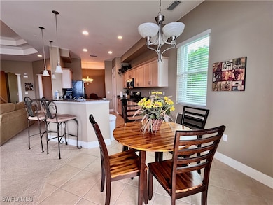 Eat in Kitchen dining featuring a chandelier, light tile patterned floors, recessed lighting, and light carpet with views of the water