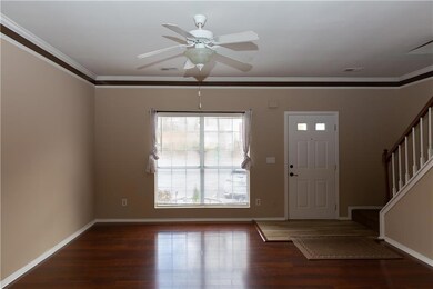 Foyer featuring stairs, wood finished floors, a ceiling fan, and crown molding