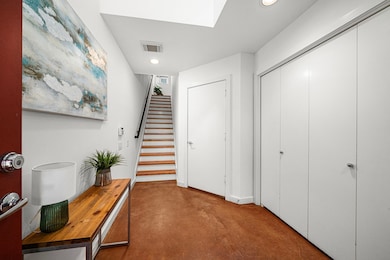 Welcome to a sleek, modern entryway featuring a po