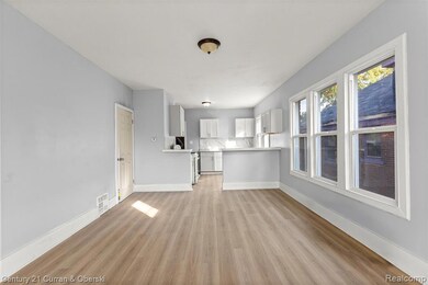 Unfurnished living room with light wood-style floors and baseboards