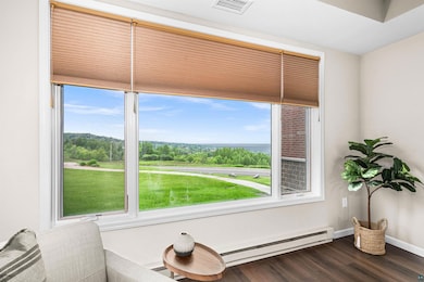 Sitting room with dark wood-style flooring and a baseboard radiator