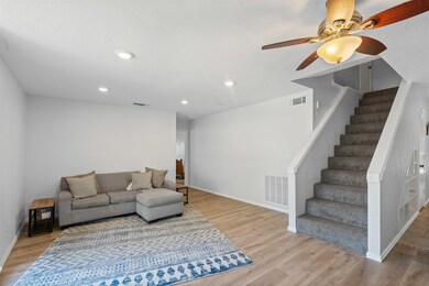 Living room with light wood-style flooring, recessed lighting, stairs, and a ceiling fan