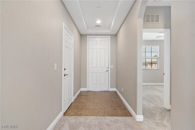 Hallway with carpet flooring, baseboards, a raised
