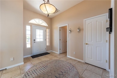 Foyer entrance with light tile patterned flooring,