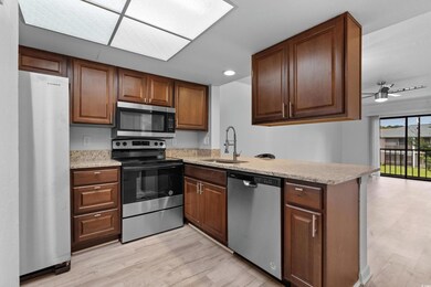 Kitchen with sink, kitchen peninsula, light hardwo