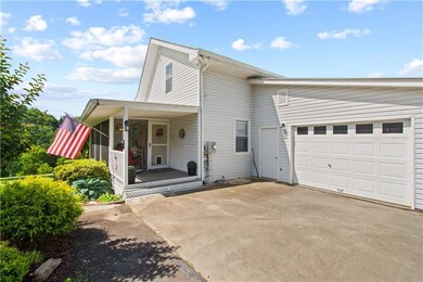 Traditional home featuring concrete driveway, a porch, and a garage
