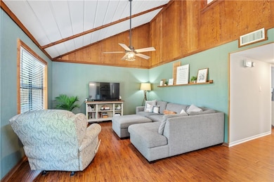 Living area with wood finished floors, lofted ceiling, a ceiling fan, baseboards, and wooden ceiling