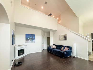 Living area with wood finished floors, a high cei