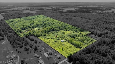 Aerial overview of property's location with property parcel outlined and a heavily wooded area