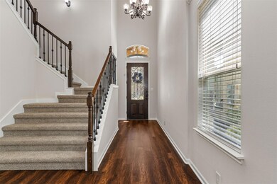 Entryway with dark wood-type flooring, a chandeli