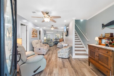 Living room featuring ceiling fan, ornamental mold