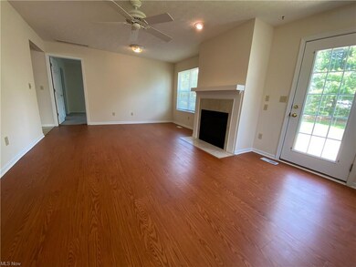 The large great room with a gas fireplace. The win