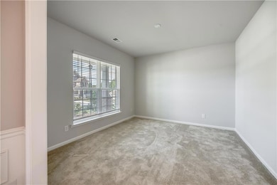 Unfurnished room with light carpet and baseboards