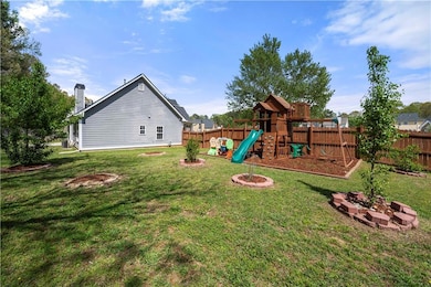 View of yard featuring an outdoor fire pit, a fenc