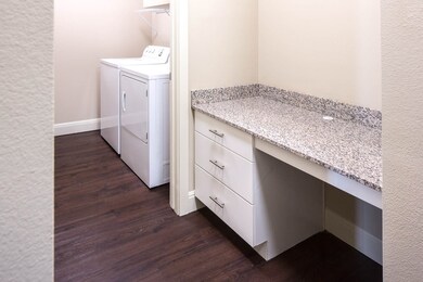 Laundry room with dark wood-style floors and washer and dryer