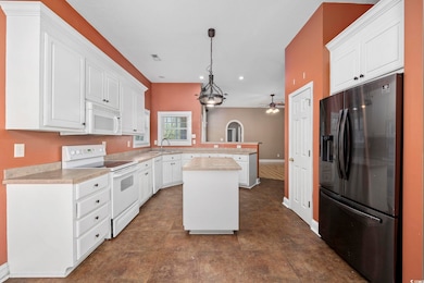 Kitchen with light countertops, a peninsula, white