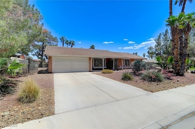 Ranch-style home with a garage, driveway, a tiled