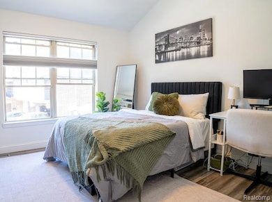 Bedroom with lofted ceiling and wood finished floors
