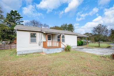 Rear view of house featuring a porch, a carport, and driveway