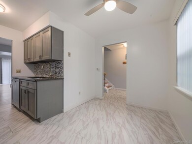 Kitchen featuring plenty of natural light, decorative backsplash, gray cabinetry, and stainless steel dishwasher