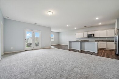 Kitchen with dark countertops, appliances with stainless steel finishes, recessed lighting, white cabinetry, and open floor plan