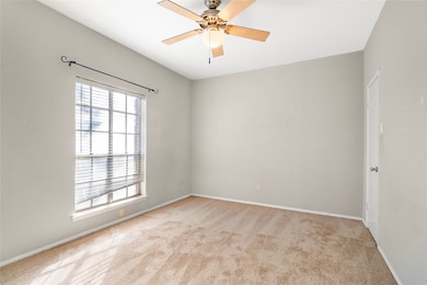 Empty room featuring carpet floors and ceiling fan