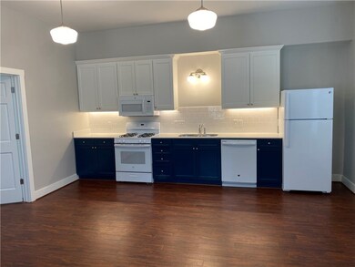 Kitchen featuring white appliances, a sink, blue c