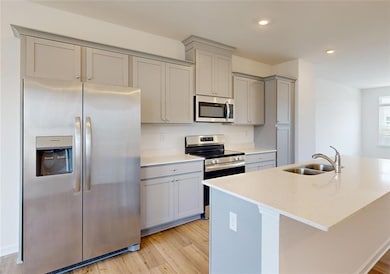 Kitchen with a kitchen island with sink, sink, lig