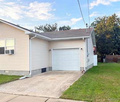 View of home's exterior with a lawn, driveway, roof with shingles, and a garage