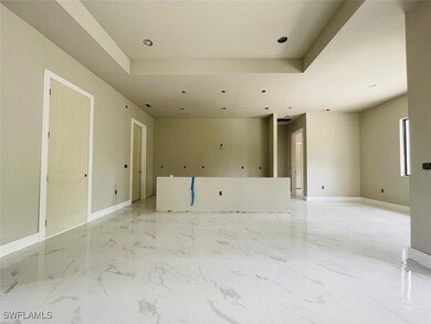 Empty room featuring a tray ceiling, light marble