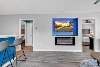 Living room with a ceiling fan, a glass covered fi