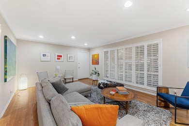 Living area featuring recessed lighting, wood finished floors, and ornamental molding