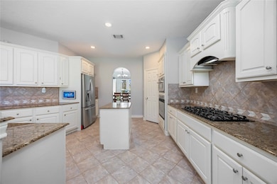 Open and functional kitchen with granite surfaces, double ovens, and a central island ideal for everyday cooking