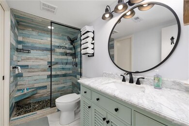 Full bath with walk in shower, toilet, and vanity