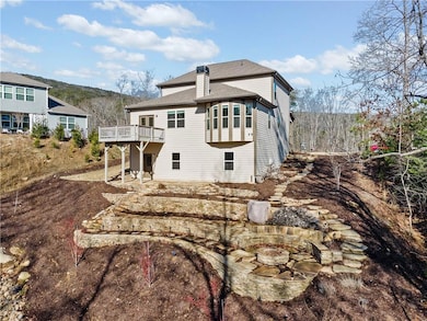 Back of house with an outdoor fire pit, a wooden deck, a chimney, roof with shingles, and a patio area