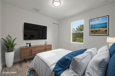 Bedroom with light wood finished floors and basebo