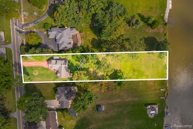 Aerial view of residential area featuring a nearby body of water and property parcel outlined