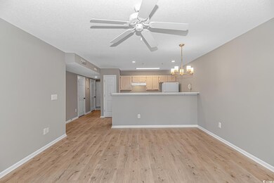 Kitchen with light brown cabinets, white fridge, l