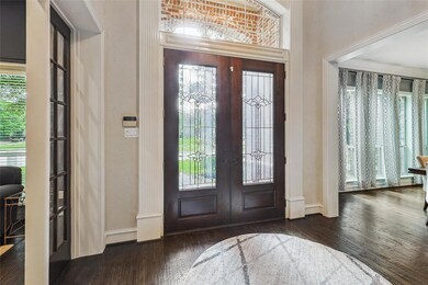 Foyer entrance with french doors, ornamental molding, and dark hardwood / wood-flooring.