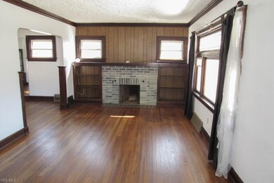 The living room offers hardwood flooring and a brick fireplace.