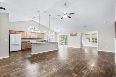 Kitchen featuring white appliances, dark hardwood 