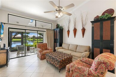 Living room featuring ornamental molding, light tile patterned flooring, a ceiling fan, a water view, and a skylight
