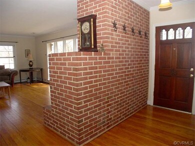 Entrance foyer has exposed brick wall with coat ho