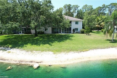 Rear view of house featuring a water view and a lawn
