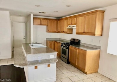 Kitchen with gas stove, under cabinet range hood,