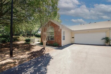 Single story home with driveway, brick siding, and an attached oversized 1 car garage