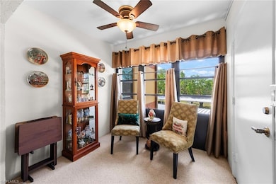 Sitting room with ceiling fan and light carpet