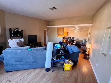 Living room featuring wood finished floors, a ceiling fan, and a textured wall