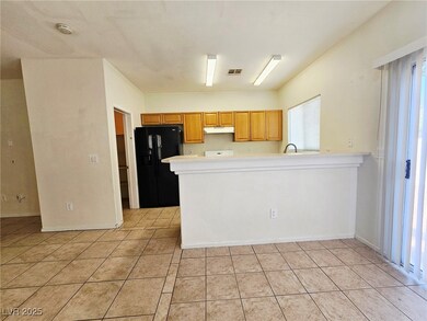 Kitchen with black refrigerator with ice dispenser